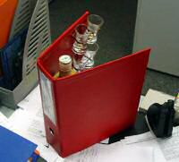 image cachette bouteille alcool dans classeur rouge insolite